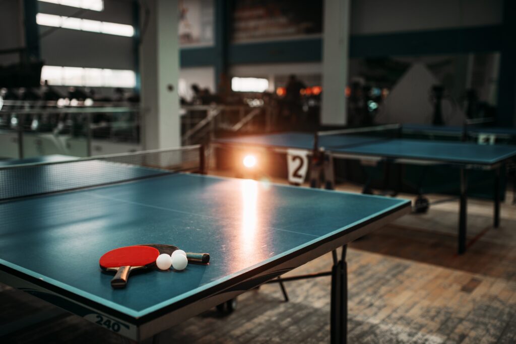 Ping pong table, rackets and balls in a sport hall